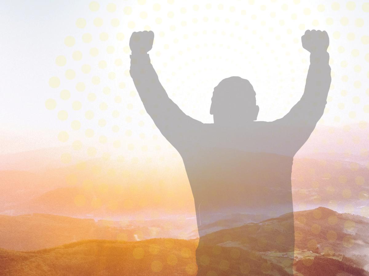 optimistic sunrise over mountains with victorious male silhouette